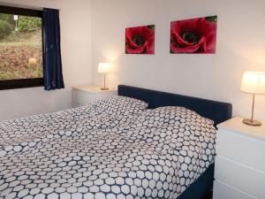 a bedroom with a bed and two paintings on the wall at Apartment Am Sternberg 250 by Interhome in Frankenau