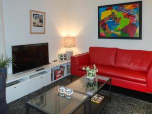 a living room with a red couch and a tv at Apartment Am Sternberg 250 by Interhome in Frankenau