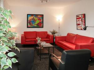 a living room with red couches and a table at Apartment Am Sternberg 250 by Interhome in Frankenau