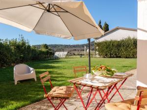 a table and chairs with an umbrella on a patio at Apartment Antonella by Interhome in Castiglione della Pescaia