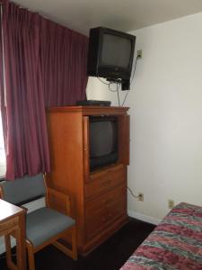 una habitación de hotel con TV en la parte superior de un tocador en Lees Motel, en Edison