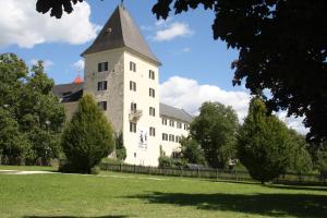 a large white building with a tower in a park at Ferienwohnung Domitian in Millstatt