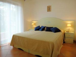 een slaapkamer met een groot bed met blauwe kussens bij Apartment K Plus by Interhome in Valledoria