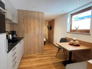a kitchen with a table and a wooden door at Apartment Neuner by Interhome in Hippach
