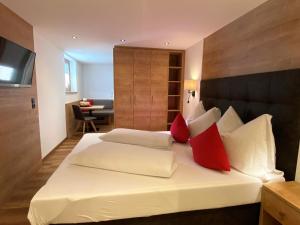 a bedroom with a large white bed with red pillows at Apartment Neuner by Interhome in Hippach