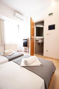 2 Betten in einem Zimmer mit einem Bad mit einem Waschbecken in der Unterkunft Athens Studios in Athen + 37 Fotos