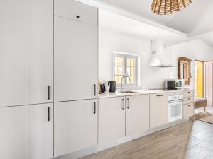 Una cocina blanca con gabinetes blancos y un fregadero. en Holiday Home Quinta de Santa Emilia 2 by Interhome, en São Martinho