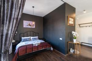 a bedroom with a bed and a black wall at Retro Studio Old Town Apartment by Hostlovers in Kaunas