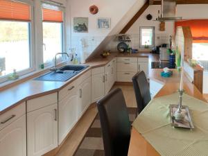 a kitchen with a sink and a table with chairs at Apartment Osterloh by Interhome in Hage