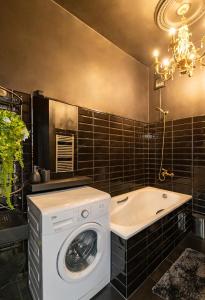 La salle de bains est pourvue d'un lave-linge et d'une baignoire. dans l'établissement Retro Studio Old Town Apartment by Domvia, à Kaunas 5 autres photos