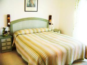 a bedroom with a bed with a striped blanket at Villa Villa Roberto by Interhome in Miami Platja