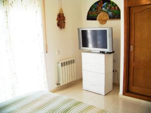 a bedroom with a tv on top of a dresser at Villa Villa Roberto by Interhome in Miami Platja +16 photos