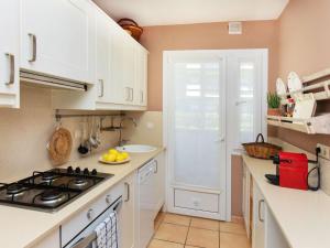 La cuisine est équipée de placards blancs et d'un four avec plaques de cuisson. dans l'établissement Apartment Chelo by Interhome, à Calella de Palafrugell