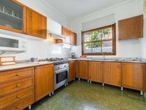 a large kitchen with wooden cabinets and a window at Holiday Home Can Xiroia by Interhome in Alcudia