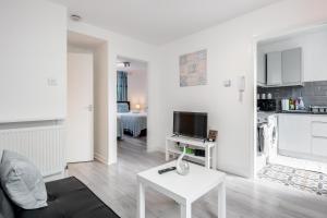 a white living room with a couch and a table at Beautiful 1-Bed Apartment in London Lewisham in London