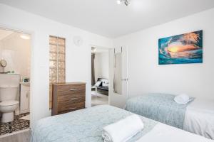 a white room with two beds and a bathroom at Beautiful 1-Bed Apartment in London Lewisham in London