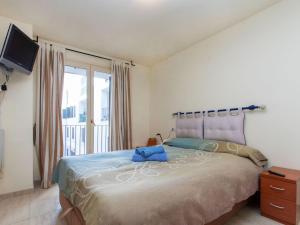 ein Schlafzimmer mit einem großen Bett und einem TV in der Unterkunft Apartment Mitsu by Interhome in Tossa de Mar