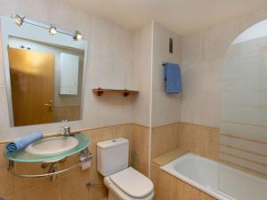 ein Badezimmer mit einem Waschbecken, einem WC und einem Spiegel in der Unterkunft Apartment Mitsu by Interhome in Tossa de Mar