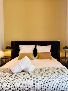 - un grand lit avec 2 oreillers dans l'établissement La note dorée, à Vichy