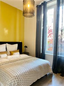 - une chambre avec un grand lit et une fenêtre dans l'établissement La note dorée, à Vichy
