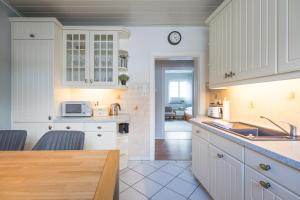 Una cocina con gabinetes blancos y encimera. en Onkel Theodor, en Husum