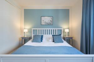 Un dormitorio con una cama azul y blanca con dos lámparas. en Onkel Theodor, en Husum