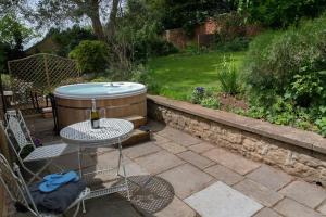 een patio met een hot tub en een tafel en stoelen bij Loft Apartment nr Bath & Bristol with hot tub in Bristol