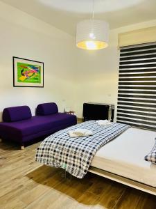 a bedroom with a bed and a purple couch at La Vacanzella al Gesu' Nuovo in Naples