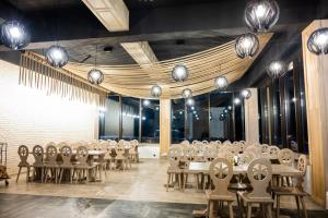 a dining room with tables and chairs and lights at Pensiunea Mama Cozonacilor in Bran