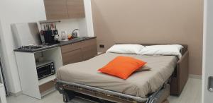un cuscino arancione su un letto in cucina di Napoli Capitale a Napoli