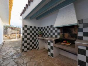 a kitchen with black and white checkered tiles on the wall at Holiday Home Arenal by Interhome in L'Ampolla