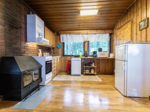 uma cozinha com electrodomésticos brancos e paredes de madeira em Holiday Home Niemeke by Interhome em Kotalahti