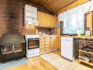 uma cozinha com electrodomésticos brancos e uma parede de tijolos em Holiday Home Niemeke by Interhome em Kotalahti