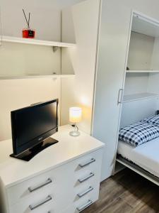 een slaapkamer met een bureau, een tv en een bed bij La Vacanzella al Gesu' Nuovo in Napels