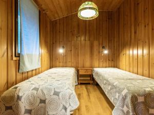 1 Schlafzimmer mit 2 Betten in einem Holzzimmer in der Unterkunft Holiday Home Niemeke by Interhome in Kotalahti