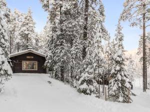 a cabin in the woods covered in snow at Holiday Home Lakka by Interhome in Salla