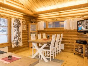 a dining room with a table and chairs in a log cabin at Holiday Home Lakka by Interhome in Salla