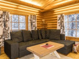 a living room with a couch and a coffee table at Holiday Home Lakka by Interhome in Salla +6 photos
