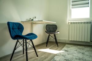 2 sillas y una mesa en una habitación con ventana en Studio Lupul, en Petrila