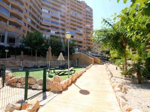 a wooden walkway with a table and an umbrella at Apartment Torre Mestral by Interhome in Cala de Finestrat