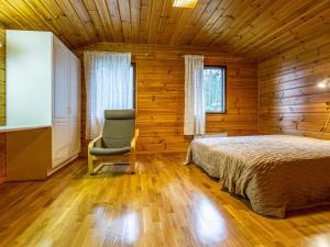 a bedroom with a bed and a chair in a room at Holiday Home Lahdeke by Interhome in Kotalahti