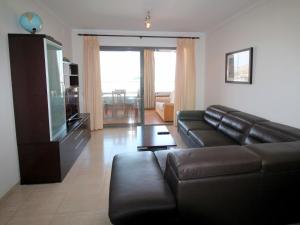 un soggiorno con divano in pelle nera e TV di Apartment Torre Mestral by Interhome a Cala de Finestrat