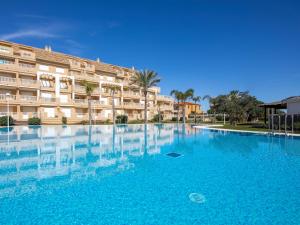 a large swimming pool in front of a building at Apartamento Tamarindo - Ubicación Premium Frente a la Playa con Piscina in Denia