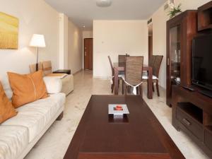 a living room with a couch and a table at Apartamento Tamarindo - Ubicación Premium Frente a la Playa con Piscina in Denia