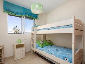 a bedroom with two bunk beds and a window at Apartamento Tamarindo - Ubicación Premium Frente a la Playa con Piscina in Denia
