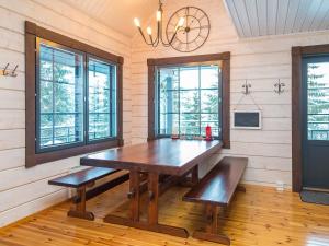 ein Esszimmer mit einem Holztisch und Bänken in der Unterkunft Holiday Home Tahkomäki by Interhome in Nilsiä