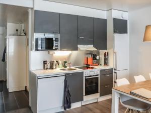 uma cozinha com utensílios de aço inoxidável e uma mesa em Holiday Home Lakevillas b1 price includes 4 ski passe by Interhome em Hyrynsalmi