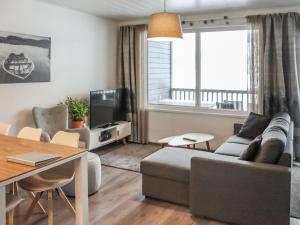 uma sala de estar com um sofá e uma mesa em Holiday Home Lakevillas b1 price includes 4 ski passe by Interhome em Hyrynsalmi