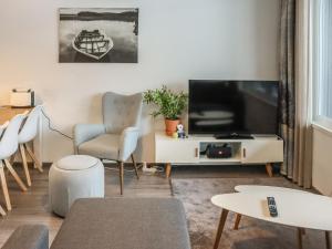 a living room with a television and a chair at Holiday Home Lakevillas b1 price includes 4 ski passe by Interhome in Hyrynsalmi +22 photos