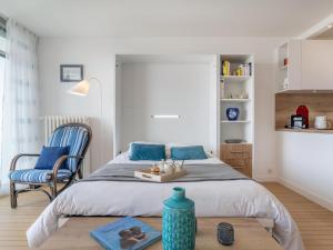 a bedroom with a bed and a chair and a table at Apartment Les Trois Iles-10 by Interhome in Quiberon